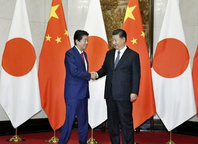Japan's Prime Minister Shinzo Abe (L) shakes hands with China's President Xi Jinping during a meeting in Beijing, China in this photo taken by Kyodo October 26, 2018. Picture taken on October 26, 2018. Kyodo via REUTERS ATTENTION EDITORS - THIS IMAGE WAS PROVIDED BY A THIRD PARTY. JAPAN OUT. NO COMMERCIAL OR EDITORIAL SALES IN JAPAN. MANDATORY CREDIT: KYODO TPX IMAGES OF THE DAY - RC1E540D9FC0