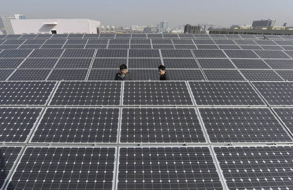Employees inspect newly-made solar panels on the roof of a Sungrow Power Supply Co., Ltd factory in Hefei, Anhui province December 8, 2010. China's strategic industries will grow at an average rate of 24.1 percent in the years between 2011 and 2015 and growth will slow to 21.3 percent in the next five years, the official China Securities Journal said on Wednesday. The targeted sectors include alternative energy, biotechnology, new-generation information technology, high-end equipment manufacturing, advanced materials, alternative-fuel cars and energy-saving and environmentally friendly technologies. REUTERS/Stringer (CHINA - Tags: BUSINESS ENERGY SCI TECH) - RTXVIQI