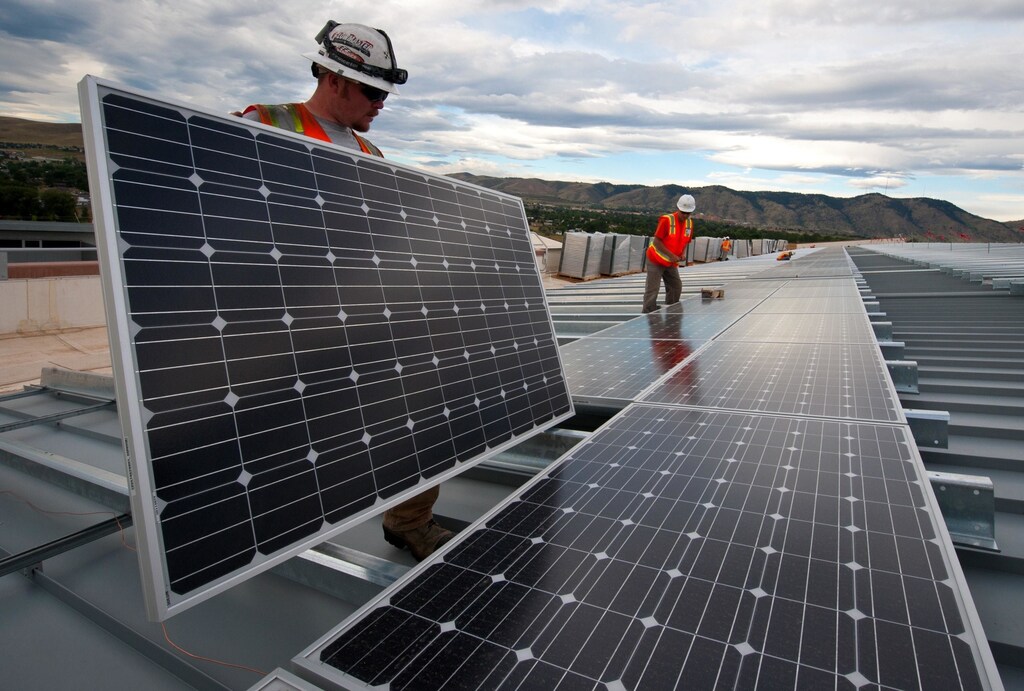 image of 2 men installing solar panels in the U.S. A successful transition to a green economy is possible, but not without proactive planning and open dialogues with workers and communities impacted by the shift
