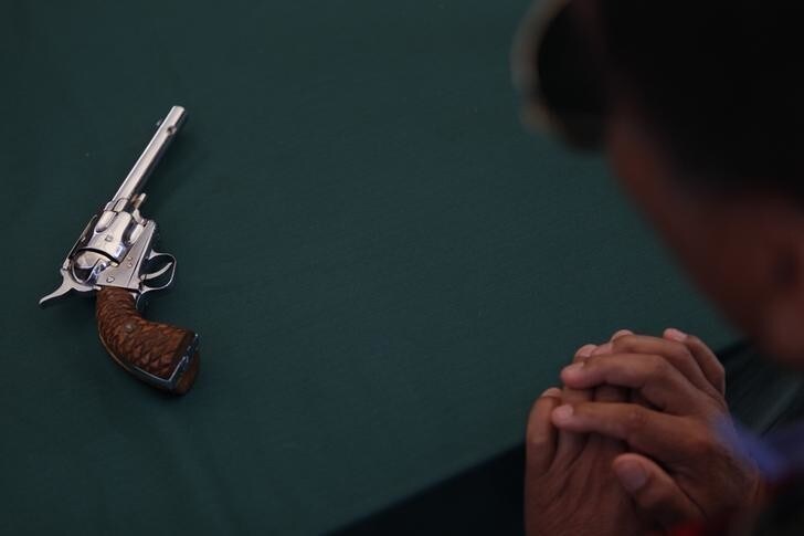 A resident swaps his gun as part of a voluntary disarmament program in Mexico City December 26, 2012. Mexico City's municipality kicked off a program to swap weapons for a tablet, bicycle or money in a low-income neighborhood in the capital, according to local media. REUTERS/Edgard Garrido (MEXICO - Tags: POLITICS SOCIETY)