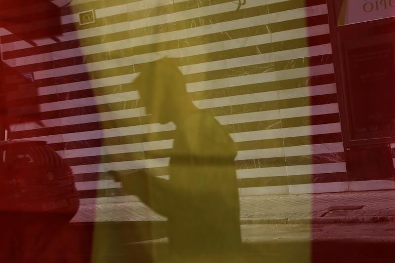 A man is seen reflected on a Spanish flag through the window of a store in Madrid, Spain, October 25, 2017. REUTERS/Susana Vera - RC1E2C555EE0