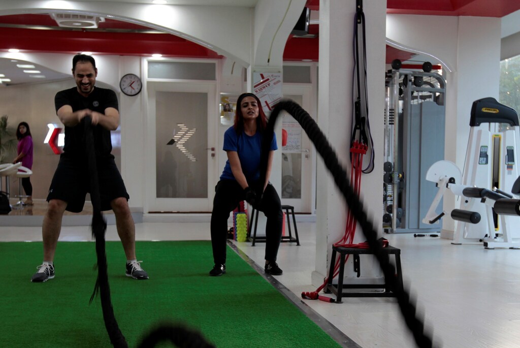 A man and woman train using battle ropes during a cross fit training at a gym in Islamabad, Pakistan September 22, 2017. REUTERS/Caren Firouz - RC182F2A3500
