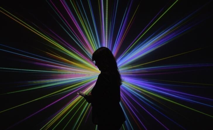 Science Museum employee Kerry Law poses for a photograph by an audio visual display at the Large Hadron Collider exhibition at the Science Museum in London November 12, 2013. The exhibition is a behind-the-scenes look at the CERN particle physics laboratory in Switzerland, where the realisation of British scientist and Nobel laureate Peter Higgs' theory on the Higgs boson took place. REUTERS/Toby Melville (BRITAIN - Tags: ENERGY ENVIRONMENT SCIENCE TECHNOLOGY)
