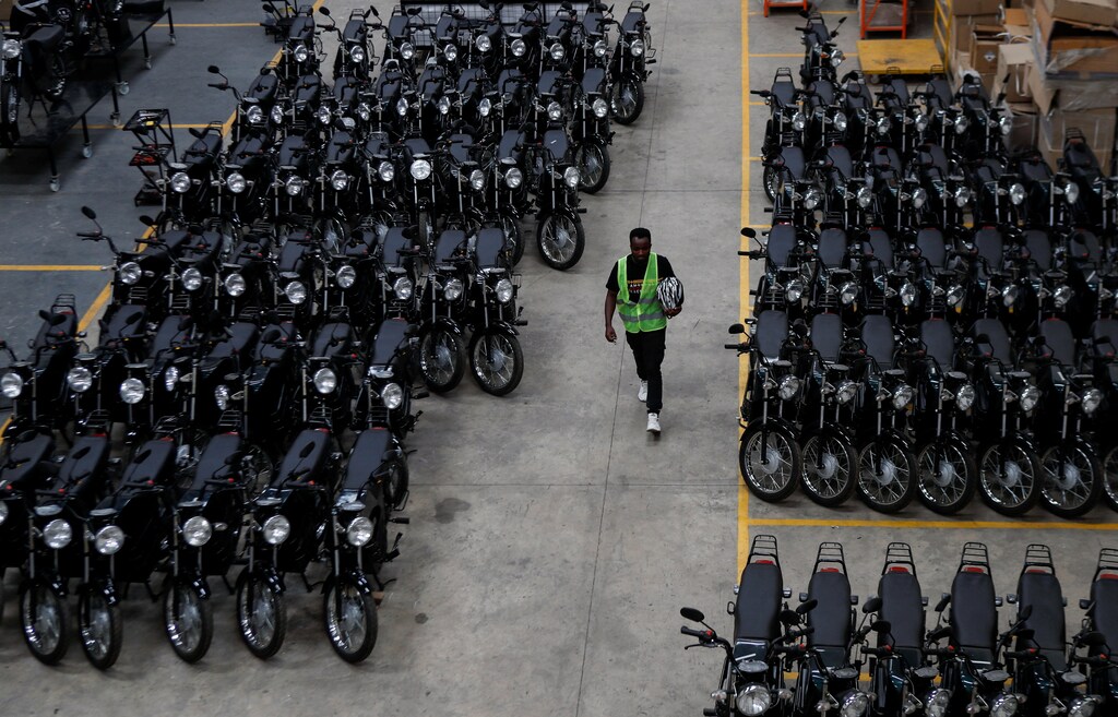 Un trabajador camina junto a motocicletas eléctricas ensambladas en el almacén de ARC Ride en Industrial Area, Nairobi, Kenia 2 de noviembre de 2022.