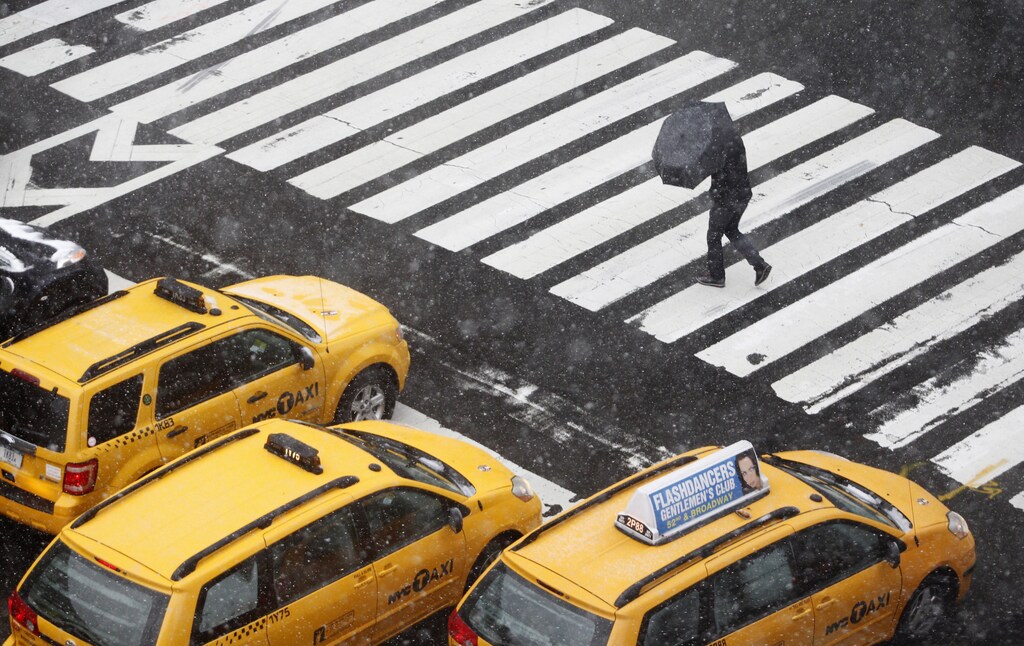 A pedestrian crosses the street during a snowstorm in New York, October 29, 2011. A rare October snowstorm bore down on the heavily populated U.S. Northeast on Saturday, with some areas bracing for up to a foot (30 cm) of snow and major power outages. REUTERS/Jessica Rinaldi (UNITED STATES - Tags: ENVIRONMENT SOCIETY) - GM1E7AU097O01