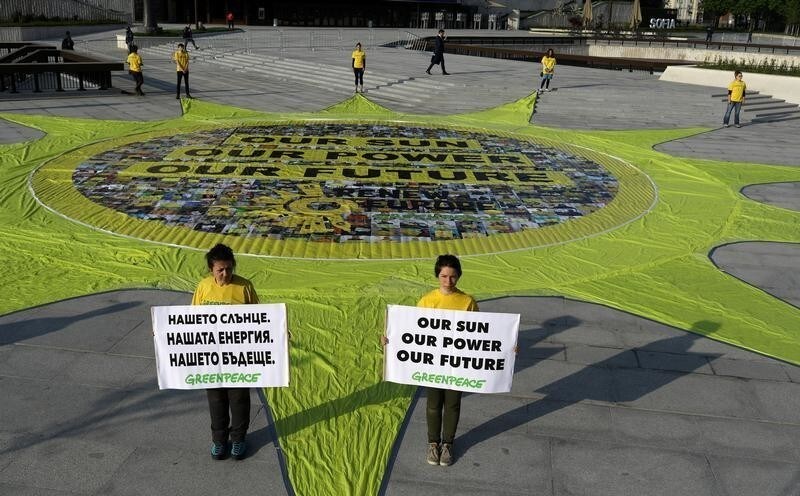 Activists of the environmental organisation Greenpeace demonstrate next to a sun-shaped banner during an EU energy ministers informal meeting in Sofia, Bulgaria, April 19, 2018.