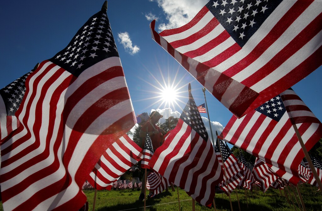 A man takes part in planting some of the 3,000 U.S. flags placed in memory of the lives lost in the September 11, 2001 attacks, at a park in Winnetka, Illinois, September 10, 2016. REUTERS/Jim Young TPX IMAGES OF THE DAY - S1BEUAOPVWAA