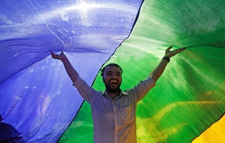 A supporter of the lesbian, gay, bisexual and transgender (LGBT) community holds a rainbow flag as he celebrates after the Supreme Court's verdict of decriminalizing gay sex and revocation of the Section 377 law, during a march in Mumbai, India, September 6, 2018. REUTERS/Francis Mascarenhas