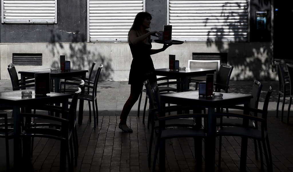 A waiter prepares tables for costumers in a terrace outside a restaurant in central Madrid, Spain, August 26, 2015. The Spanish economy expanded at a 1 percent clip in the second quarter from the first, its fastest pace in more than eight years as consumer spending powered ahead, data showed on Thursday. Picture taken on August 26, 2015. REUTERS/Sergio Perez - GF10000183323