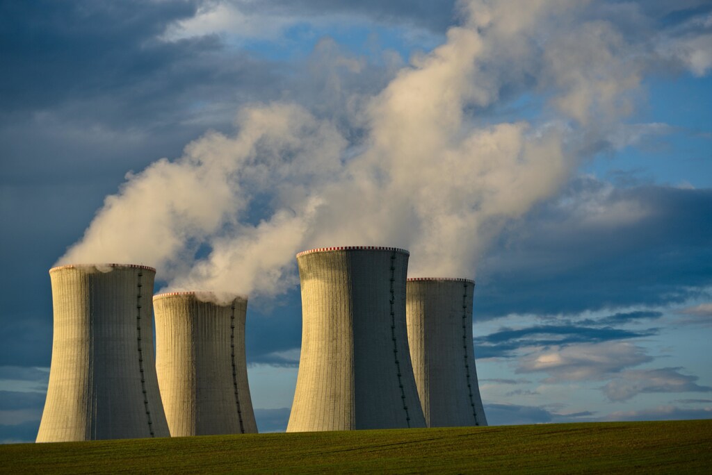 Gray concrete nuclear power plant under blue sky.