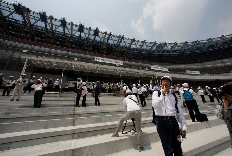 Workers and media members are seen at the construction site of the New National Stadium, the main stadium of Tokyo 2020 Olympics and Paralympics, during a media opportunity in Tokyo, Japan July 18, 2018.