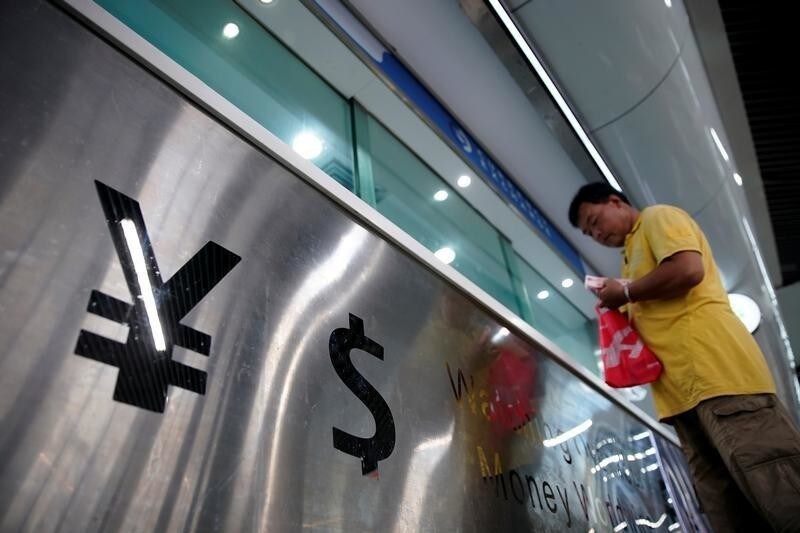 Signs of Chinese yuan and U.S. dollar are seen at a currency exchange store in Shanghai, China August 8, 2019. REUTERS/Aly Song - RC1FC82C95A0