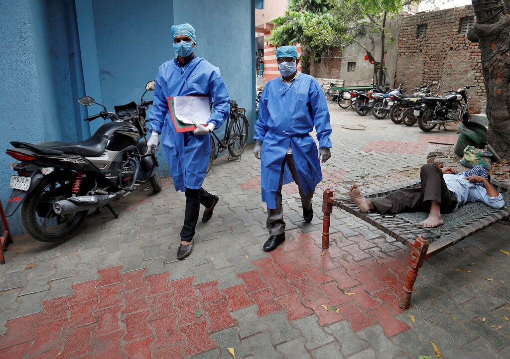 Police officers in protective suits arrive in a residential area to check on people under home quarantine, during a 21-day nationwide lockdown to limit the spreading of coronavirus disease (COVID-19), in Ahmedabad, India, March 25, 2020. REUTERS/Amit Dave - RC2YQF9PGQ3I