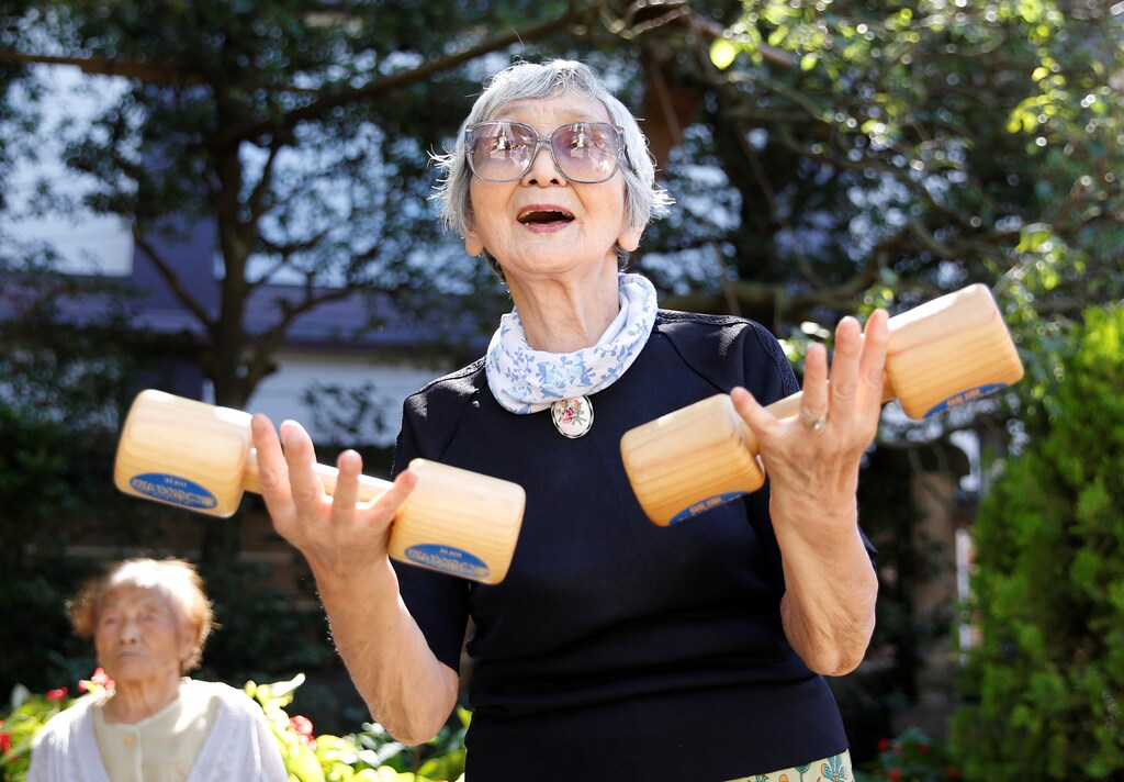 Elderly and middle-aged people exercise with wooden dumbbells during a health promotion event to mark Japan's "Respect for the Aged Day" at a temple in Tokyo's Sugamo district, an area popular among the Japanese elderly, Japan, September 18, 2017. REUTERS/Toru Hanai - RC1C0651C800