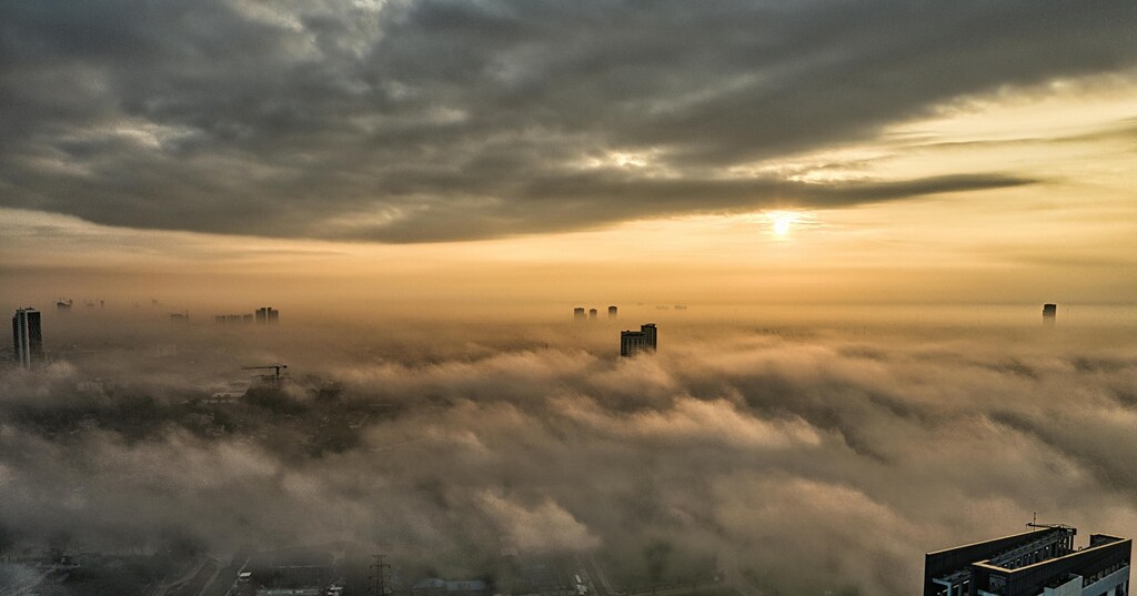 Un paisaje urbano parcialmente oculto por oscuras nubes de tormenta.