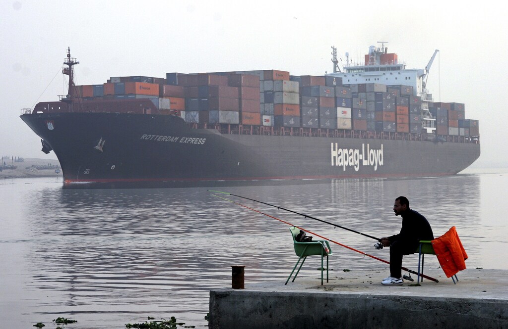A fisherman sits on the bank of the Suez Canal in Ismailia, Egypt in this December 14, 2005 file photo. Winding through this small Egyptian town like an artery, pumping cash into its hospitals and schools and beyond into the wider economy, the Suez Canal has flourished as a shipping shortcut. Now the faltering global economy, coupled with a rise in piracy to the canal's south, looks set to end the high times for the waterway and the town Egyptians call its bride. To match feature EGYPT-CANAL/. REUTERS/Aladin Abdel Naby/Files (EGYPT) - GM1E4AK0LUX01