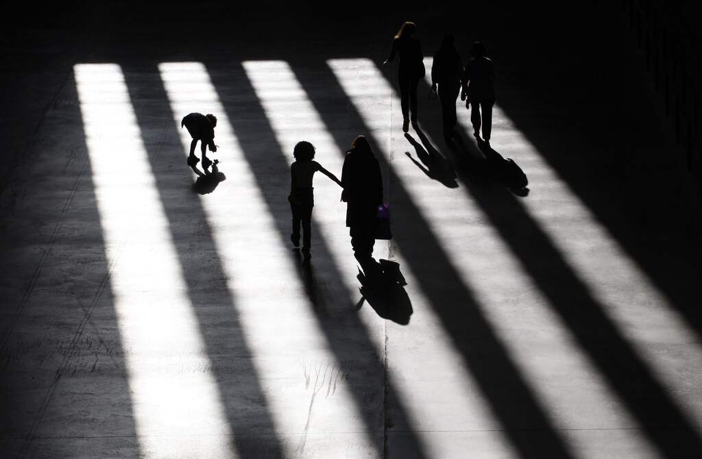 Visitors to Tate Modern walk through sunlight shining through the windows in London July 30, 2009. REUTERS/Andrew Winning (BRITAIN ENTERTAINMENT SOCIETY TRAVEL) - LM1E5840N9Q01