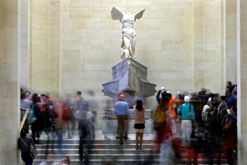 Visitors look at the Winged Victory of Samothrace, also called the Nike of Samothrace, a marble Hellenistic sculpture at the Louvre Museum in Paris, France, December 3, 2018. Picture taken December 3, 2018. REUTERS/Charles Platiau - RC17EA5E2600