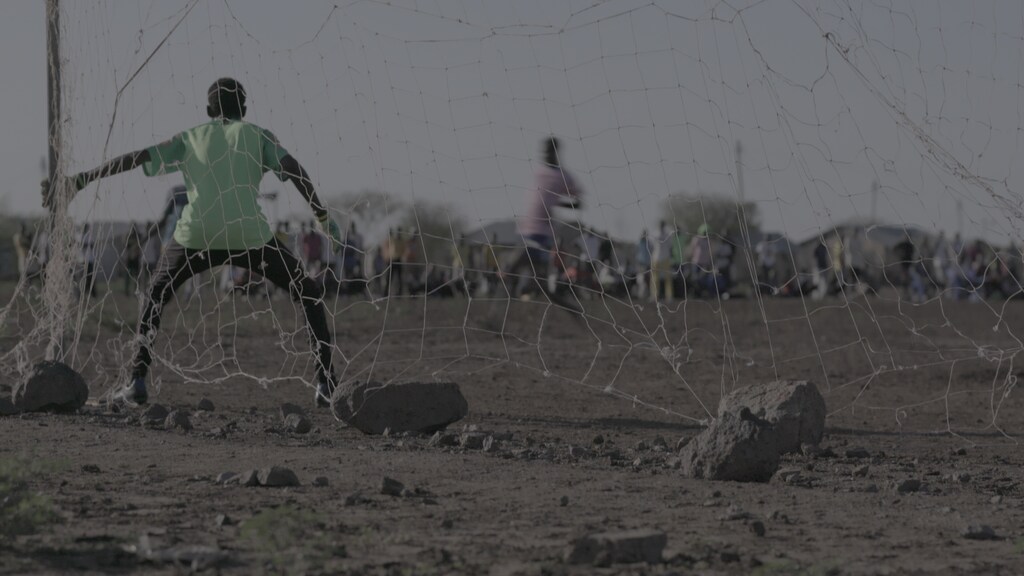 Goalkeeper in football match at Kakuma Refugee Camp: Football match at Kakuma Refugee Camp – Sports can be a unifying force for refugees worldwide.