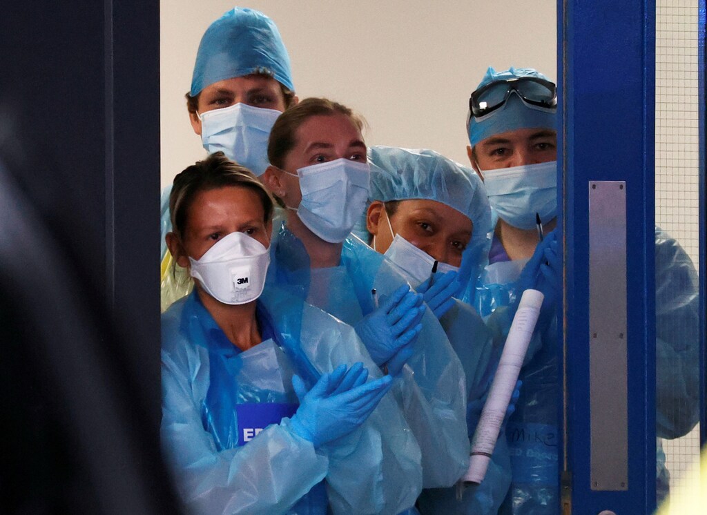 NHS workers react at the Aintree University Hospital during the Clap for our Carers campaign in support of the NHS, following the outbreak of the coronavirus disease (COVID-19), Liverpool, Britain, May 7, 2020. REUTERS/Phil Noble TPX IMAGES OF THE DAY - RC2VJG9WWA5P
