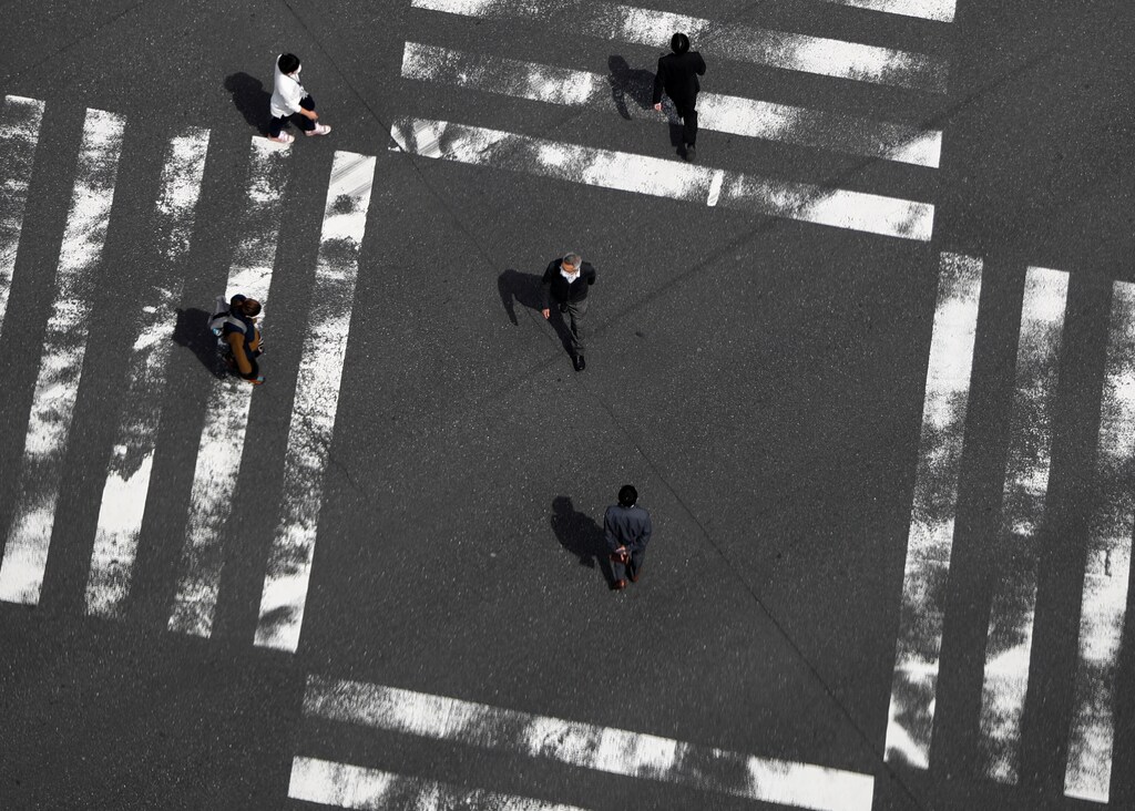 Less than usual passersby are seen at a pedestrian crossing at Ginza shopping and amusement district during the outbreak of coronavirus disease (COVID-19) on the day before a state of emergency is expected to be imposed at in Tokyo, Japan April 7, 2020. REUTERS/Issei Kato - RC2HZF9YU9QN