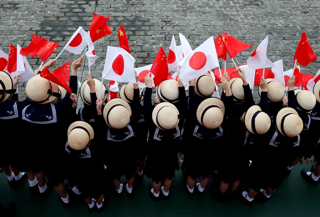 Kindergarten pupils wave national flags as Chinese Premier Li Keqiang reviews the guard of honour with Japan's Prime Minister Shinzo Abe during a welcoming ceremony before their bilateral talks at Akasaka Palace state guest house in Tokyo, Japan May 9, 2018. REUTERS/Toru Hanai TPX IMAGES OF THE DAY - RC18FF33DE90