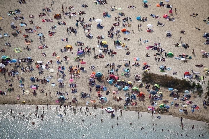 An aerial view shows people at a beach on the shores of lake Silbersee (Silver Lake) during a long-lasting heatwave over central Europe in Haltern, Germany, August 4, 2018. REUTERS/Wolfgang Rattay