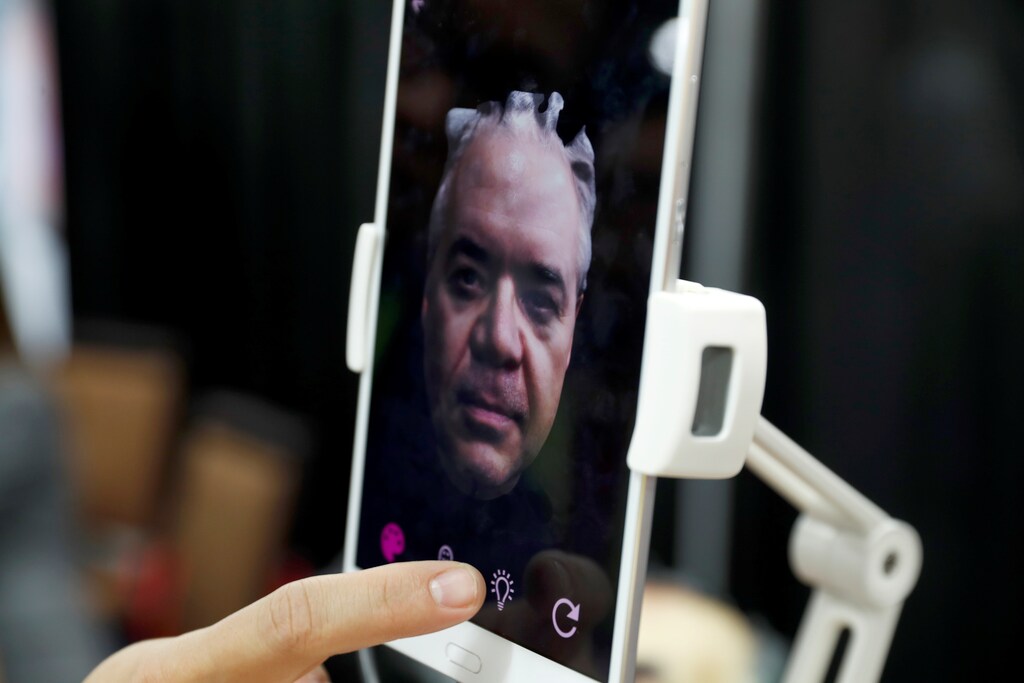 A man looks over a 3D scan of his face after trying out a Bellus3D face scanner during CES Unveiled at the 2018 CES in Las Vegas, Nevada, U.S. January 7, 2018. REUTERS/Steve Marcus - RC11A69502E0