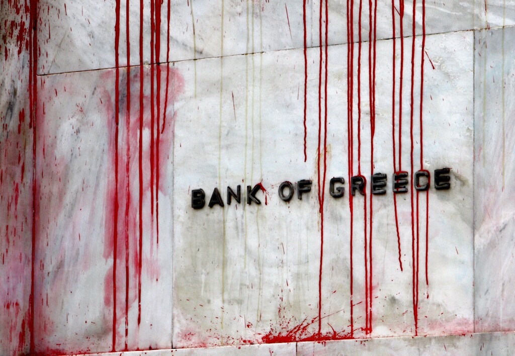 A branch of the Bank of Greece is seen stained with red paint thrown by demonstrators during a protest in central Athens, December 6, 2010.Greek police fired teargas at stone-throwing youths marching in Athens to mark the anniversary of the police killing of a 15-year-old, which triggered the country's worst riots in decades in 2008. REUTERS/Yannis Behrakis (GREECE - Tags: CIVIL UNREST)