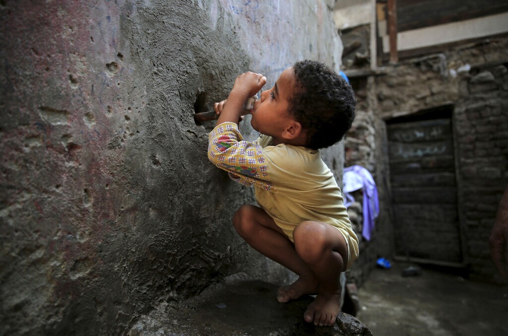 An Egyptian child drinking from a water faucet in Cairo.