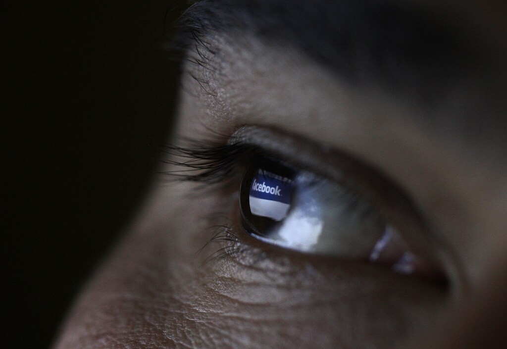 A picture illustration shows a man looking at the Facebook website on a tablet in Sofia June 27, 2012. Wall Street's top financial firms delivered highly-anticipated assessments of social networking phenomenon Facebook Inc on Wednesday, giving a cautious nod of approval about the company a month after its rocky initial public offering. Picture was flipped horizontally. REUTERS/Stoyan Nenov (BULGARIA - Tags: BUSINESS SCIENCE TECHNOLOGY) - GM1E86R1FJ201
