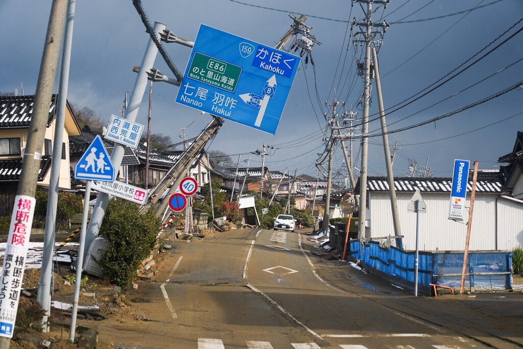 Crooked signs hang over a road damaged in the January 1 earthquake in Nishiaraya, Ishikawa Prefecture, Japan January 8, 2024. REUTERS/Joseph Campbell