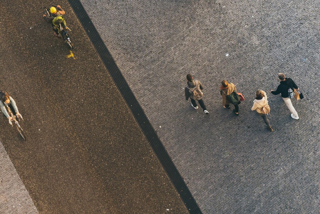 Bird's eye view of people walking and cycling on a wide pavement in a blog about 'car-light' transport