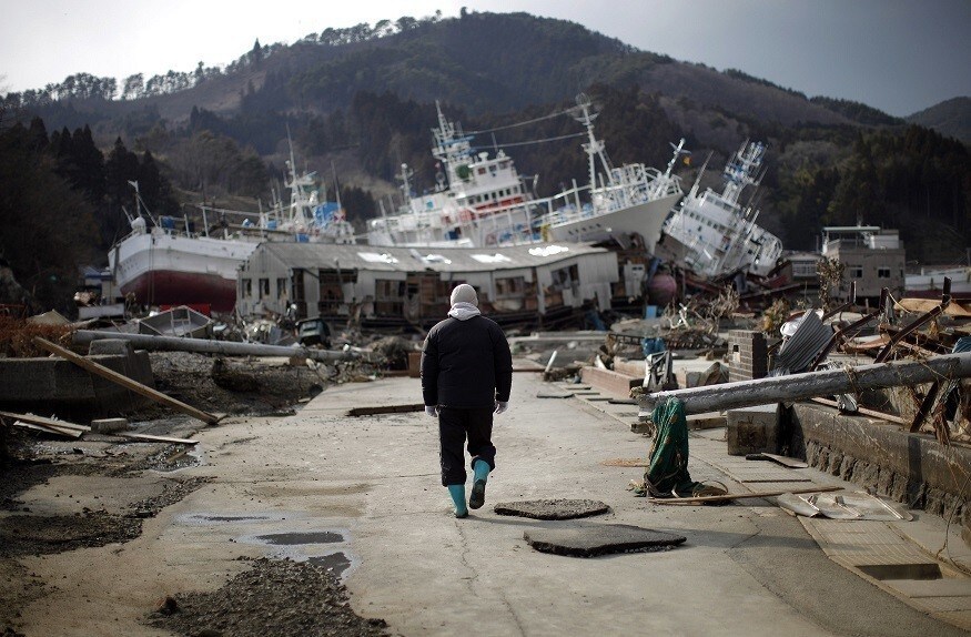 A man walks next to port area destroyed by the earthquake and tsunami in Kessenuma town, in Miyagi prefecture March 28, 2011. Japan appeared resigned on Monday to a long fight to contain the world's most dangerous atomic crisis in 25 years after high radiation levels complicated work at its crippled nuclear plant. REUTERS/Carlos Barria (JAPAN - Tags: DISASTER ENVIRONMENT) FOR BEST QUALITY IMAGE: ALSO SEE GM1E74S05GS01. - RTR2KI4R