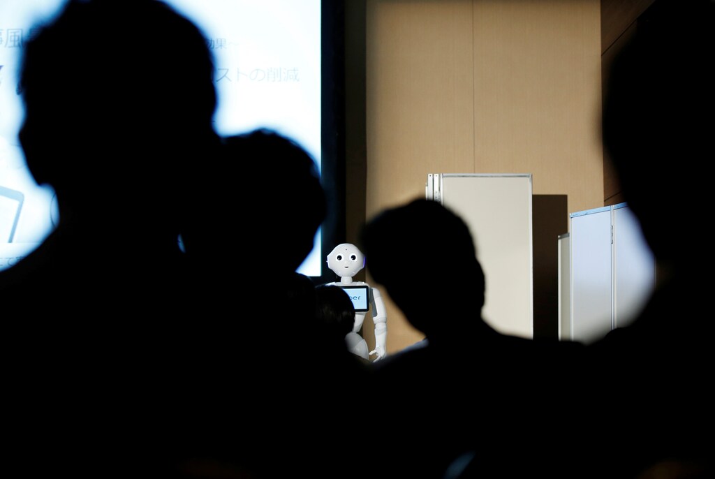 Attendants look at a SoftBank's humanoid robot Pepper on a stage during a news conference announcing its service for business customers in Tokyo, Japan, July 20, 2016. REUTERS/Kim Kyung-Hoon - RTSITBU