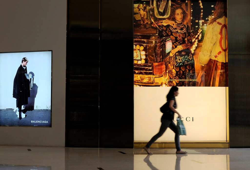 A woman runs in front of a Gucci shop at a shopping mall in Jakarta, Indonesia October 25, 2016. REUTERS/Beawiharta - RTX2QBZ8