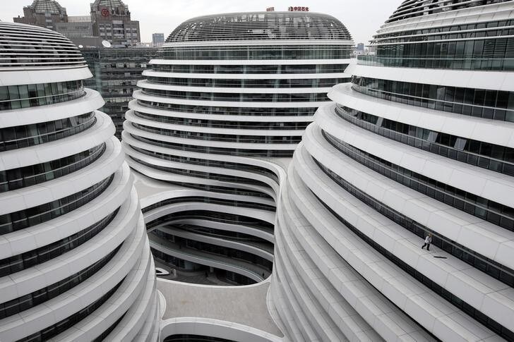 A worker cleans an exterior of a newly built urban complex building accommodating offices and retail shops in Beijing October 14, 2013. REUTERS/Kim Kyung-Hoon (CHINA - Tags: BUSINESS CONSTRUCTION TPX IMAGES OF THE DAY)