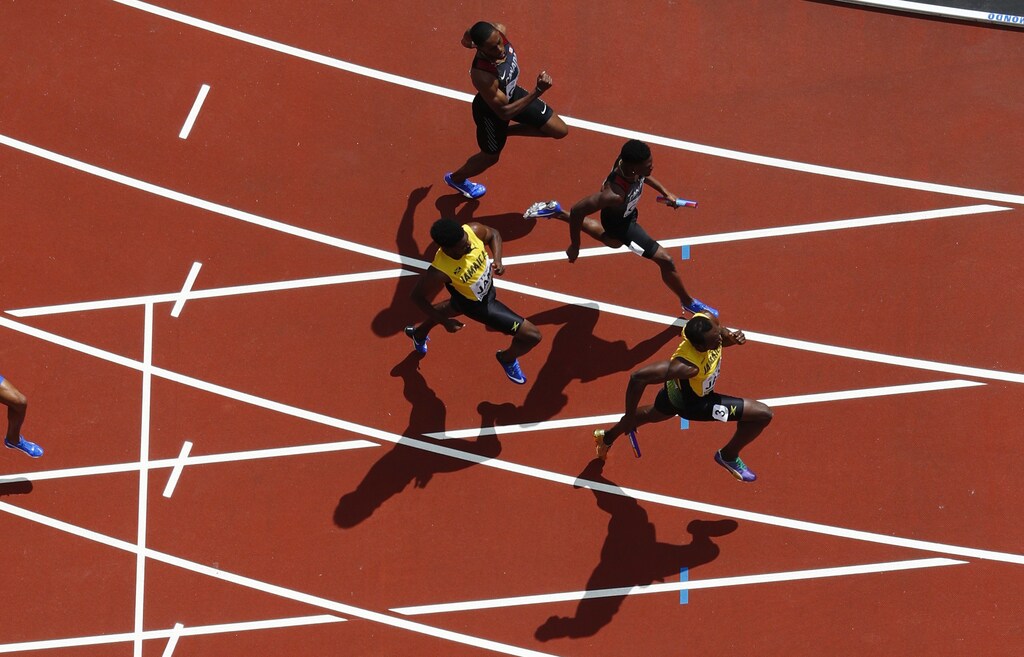 Athletics - World Athletics Championships - Men's 4x100 Metres Relay Heat 2 - London Stadium, London, Britain  August 11, 2017. Usain Bolt of Jamaica takes the baton before winning the race. REUTERS/Fabrizio Bensch - UP1ED8C0S7Z0E