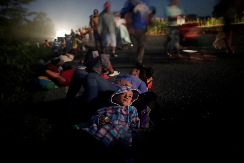 Glenda Escobar, 33, a migrant from Honduras, part of a caravan of thousands from Central America en route to the United States, rests on the road with her son Adonai, as they make their way to Pijijiapan from Mapastepec, Mexico, October 25, 2018. Reuters photographer Ueslei Marcelino: "We accompanied Glenda and her two children for 24 hours. Adonai told me that he would stay awake every night so his mother could rest. In this photo, I got one of the rare moments that remained quiet for some time. He would not stop for a minute - always smiling, jumping or running. I believe that his good-nature and positive energy, became the 'fuel' for his brother and his mother to continue the walk." REUTERS/Ueslei Marcelino SEARCH "IMMIGRATION POY" FOR THIS STORY. SEARCH "REUTERS POY" FOR ALL BEST OF 2018 PACKAGES. TPX IMAGES OF THE DAY. - RC14AD4097D0