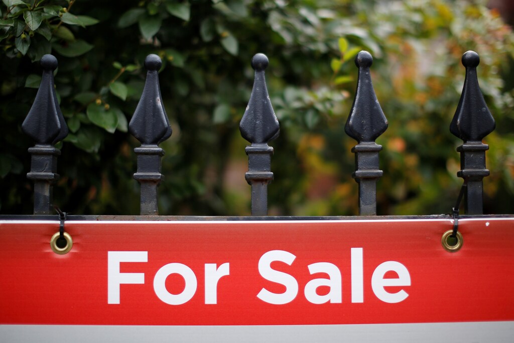 A real estate sign is seen hanging on a fence in front of a house for sale in Ottawa, Ontario, Canada, August 15, 2017. REUTERS/Chris Wattie - RC1845A57C10