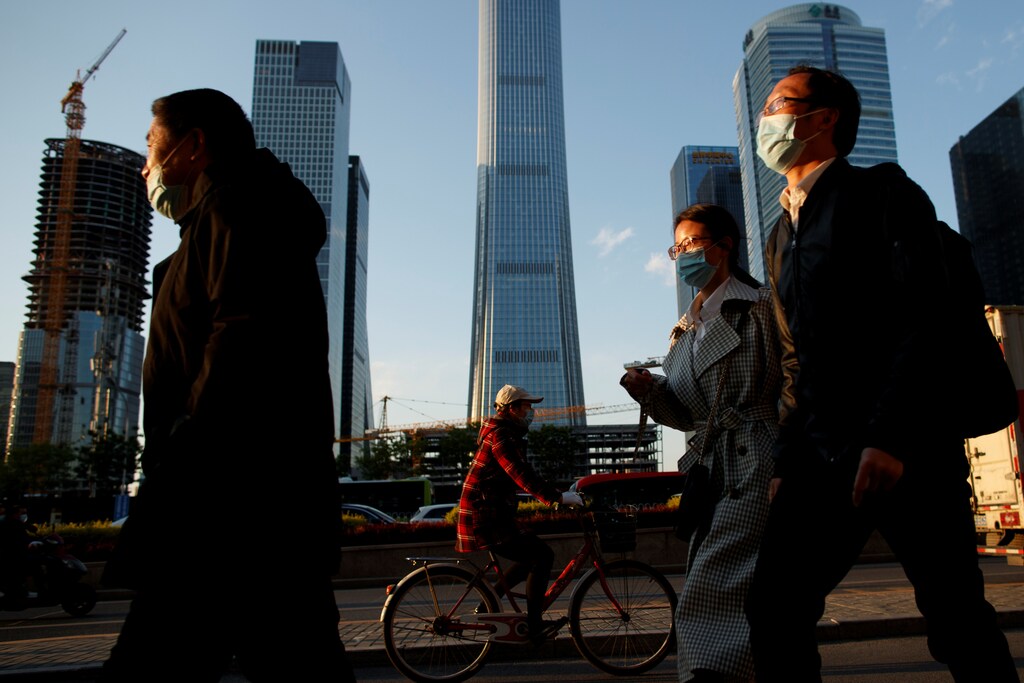 People wear protective masks as they leave work during evening rush hour in Beijing as the spread of the novel coronavirus disease (COVID-19) continues, China April 20, 2020. REUTERS/Thomas Peter - RC2B8G9WTL6Q