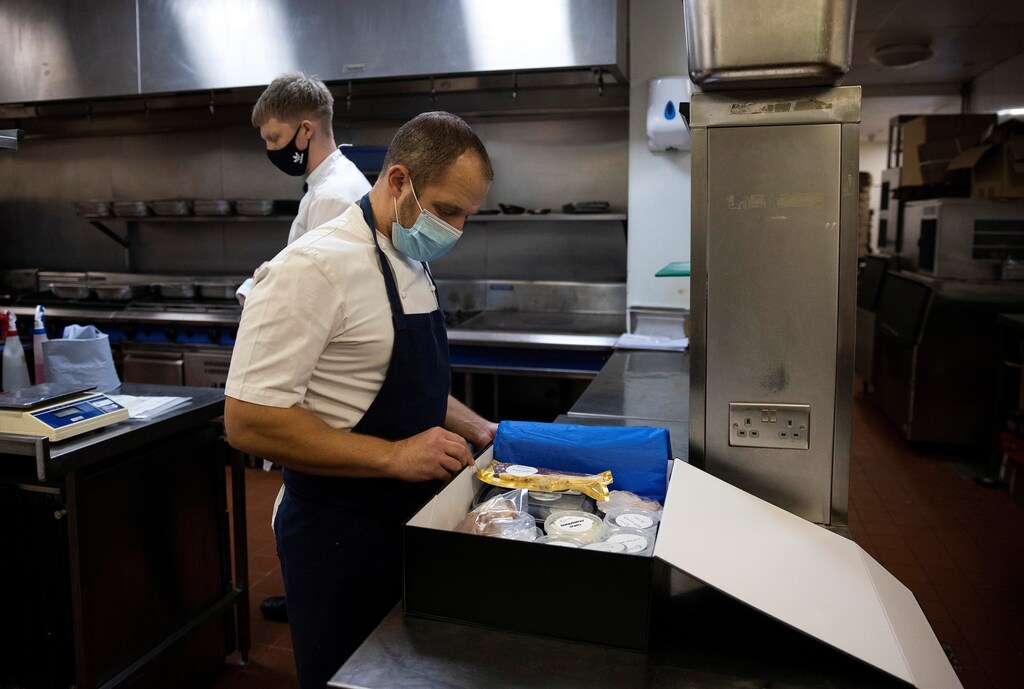 James Knappett, founder and head chef of 'Home', the first at-home fine dining experience, packs food into a box destined for customers in London, Britain, November 18, 2020. Picture taken November 18, 2020. REUTERS/Simon Dawson - RC2BAK9QVT5C