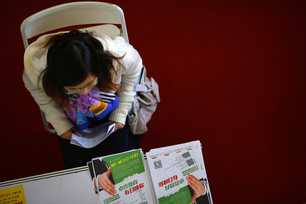 A student attends a job interview during a job fair at Donghua University in Shanghai November 20, 2014. China's economy faces increasing downward pressure in 2015 while the country pushes forward reforms to keep economic growth stable, the top economic planning body said on Wednesday. REUTERS/Carlos Barria (CHINA - Tags: POLITICS BUSINESS) - GM1EABK1RYO01