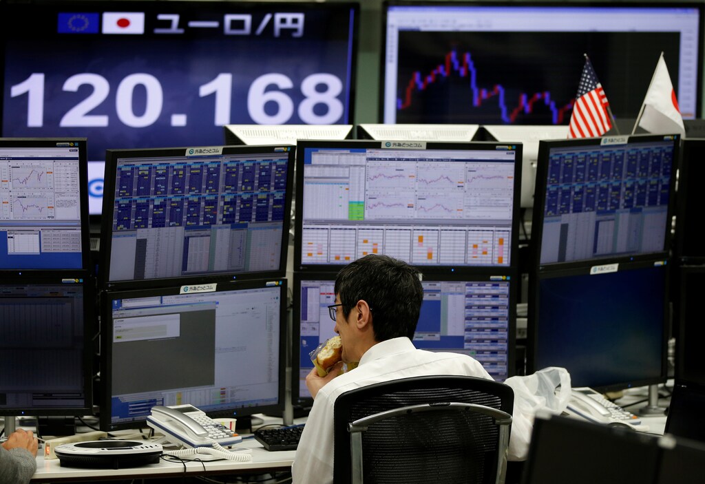 An employee of a foreign exchange trading company works in front of a monitor showing the Japanese yen's exchange rate against the euro (top L) in Tokyo, Japan, December 5, 2016. REUTERS/Toru Hanai - RTSUNQ8