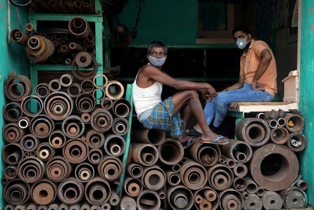 Workers wearing protective face masks sit inside a shop selling iron pipes at a wholesale iron market, after authorities eased lockdown restrictions that were imposed to slow the spread of the coronavirus disease (COVID-19), in Kolkata, India, June 15, 2020. REUTERS/Rupak De Chowdhuri TPX IMAGES OF THE DAY - RC2O9H9GTJAR