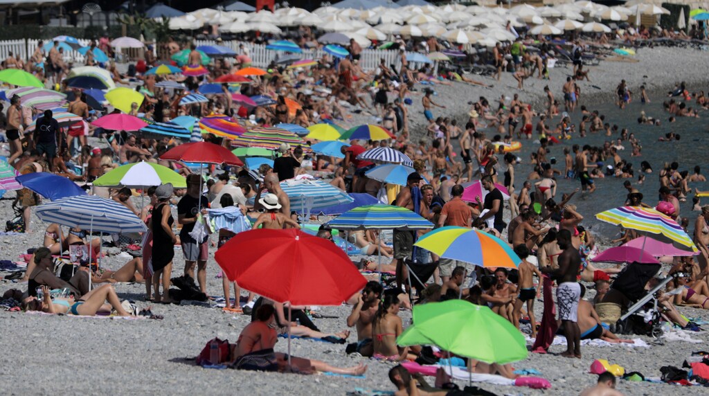 Parasols dot a crowded beach with sunbathers in Nice as summer temperatures continue and authorities maintain a heat wave alert in France, August 1, 2018.