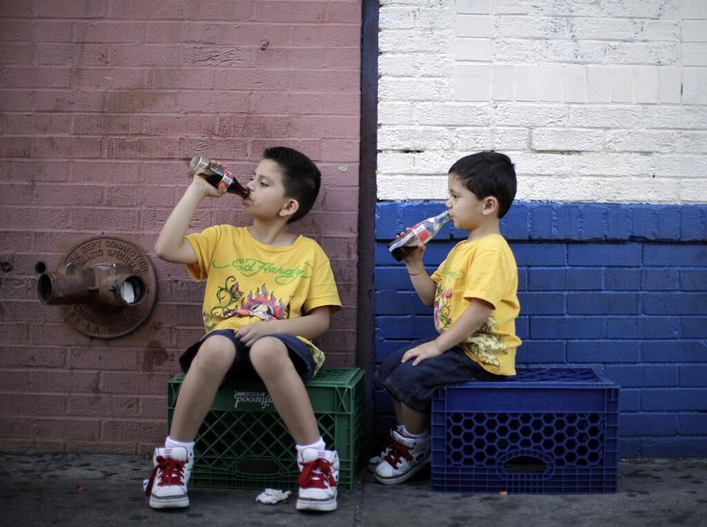 Jessie Rodriguez, 8, and his brother Christopher Rodriguez, 3, drink soda as they sit in the shade on a hot day in downtown Los Angeles April 8, 2010. REUTERS/Lucy Nicholson (UNITED STATES - Tags: SOCIETY ENVIRONMENT) - RTR2CLB7