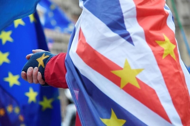 An anti-Brexit demonstrator wears a combination of EU and Union flags outside the Houses of Parliament in London, Britain, November 26, 2018. REUTERS/Toby Melville - RC1E8185F270