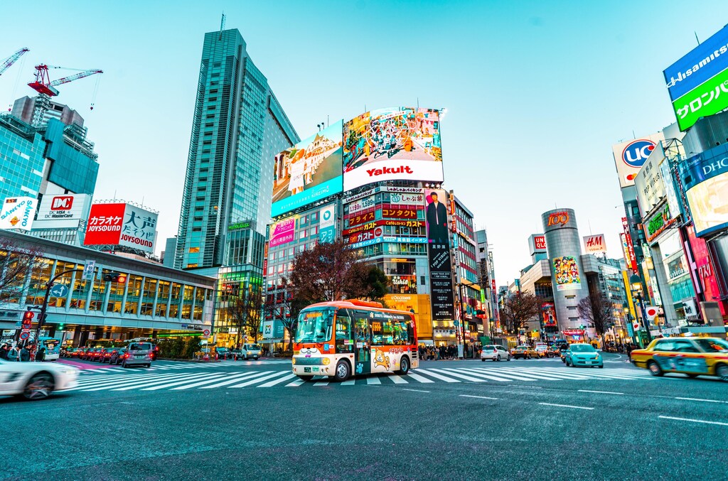 A city in Tokyo with multiple types of transportation on the road.