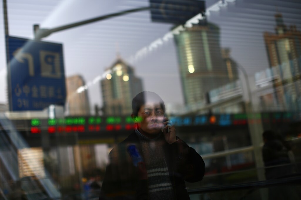 A man walks out of a subway station as he talk on the phone at the financial district of Pudong in Shanghai March 11, 2014. Beijing announced sweeping reforms late last year as it tries to shift the economy away from a reliance on the investment and exports that have fuelled double-digit expansion for three decades in favour of consumption and services, which it hopes will generate more sustainable long-term growth. REUTERS/Carlos Barria (CHINA - Tags: BUSINESS SOCIETY TPX IMAGES OF THE DAY) - GM1EA3B1J3501